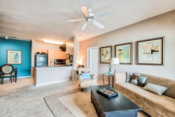 A living room with a blue wall and a white ceiling fan.